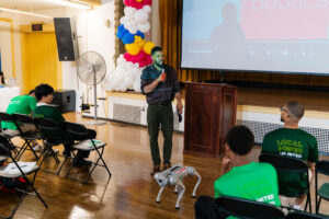 Representative from Mass Robotics brings robot dog to BDA showcase.
