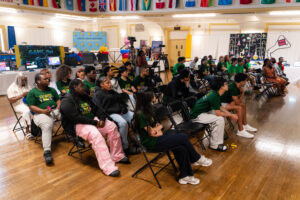 Proud students and guests listen to BDA presentations with questions in hand.