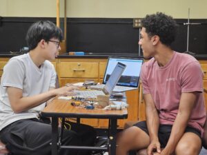 AMP students give each other feedback on their prototype design presentations.